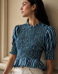 Blouse péplum smockée à col volanté