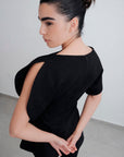 Blouse noire à manches fendues effet pétale vue dos sur modèle