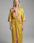 Robe midi croisée satinée jaune à imprimé floral rose, col V et manches larges vue de face