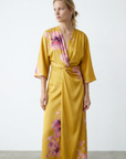 Robe satinée jaune imprimée de fleurs roses, col V et manches larges, vue de trois-quarts