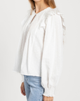Profil d’un modèle en blouse plumetis coton blanc femme, présentant les manches et le style chic, blouse femme coton.