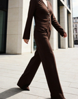Modèle en mouvement portant un ensemble deux pièces coton femme en marron, avec une veste à col V et des boutons décoratifs.