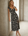 Modèle posant en robe longue noire à imprimé floral fendue côté élégante, révélant un style agréable grâce à la robe avec fente latérale.