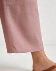 Pantalon court plissé taille haute ceinture élastique à poches rose, présenté à plat, montrant le design élégant et les finitions impeccables. Pantalon plissé femme.