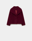 Veste courte effet poil doublée col à revers vue de face en rouge, souligant son design tendance. Veste courte femme.