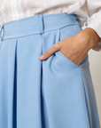Gros plan sur le pantalon fluide taille haute femme bleu, mettant en avant les poches et la texture de la matière.
