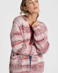 Femme regardant vers l'avant, vêtue d'un cardigan court en maille coloré, avec des poches. Ce cardigan court femme en maille est parfait pour un look décontracté.