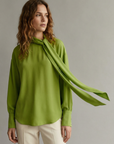 Camisa elegante verde con cuello lavallière para mujer, mangas largas, tejido fluido y cómodo.