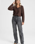 Pull fin col V femme en couleur marron, porté avec un jean noir pour un look chic et décontracté.