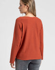 Pull fin col V femme couleur orange, présenté avec un haut gamme de styles, idéal pour le jour.