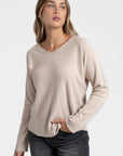 Pull fin col V femme beige, présenté dans une tenue simple et élégante pour toutes occasions.