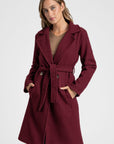 Manteau croisé femme en bordeaux, portant bien la ceinture, idéal pour un style élégant.