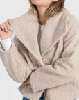 Détail d'une femme dans une veste courte effet poil doublée col à revers, soulignant le confort et le style. Veste courte femme.