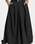 Détail du pantalon fluide taille haute femme noir, montrant les plis et une ceinture, avec une apparence chic.