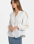 Femme en chemise brodée en coton, montrant les détails des broderies sur les manches. Chemise brodée femme idéale pour un look moderne.