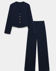 Image de l'ensemble deux pièces coton femme en bleu marine, avec une veste à col V et un pantalon structuré, présenté sur fond blanc.