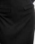 Zoom sur une jupe midi noire avec détails de poches, conçue pour un style chic et moderne.