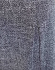 Détail du tissu d'une jupe midi structurée taille haute ceinture noire. Un style en jupe grise, offrant un mélange de confort et d'élégance.