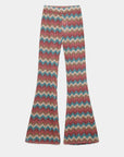 Pantalon flare taille haute fluide imprimé en zigzag multicolore sur fond blanc.
