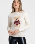 Pull jersey motif ours en mohair laine, coloris écru, porté par une femme avec un léger sourire, offrant une allure chaleureuse et accueillante.