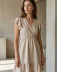 Robe fluide manches courtes en polyester légère — coupe féminine, modèle beige, femme dans un cadre moderne.
