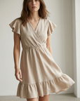 Robe fluide manches courtes en polyester légère — coupe féminine, modèle beige portée par une femme.