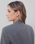 Profil d'une femme portant un blazer femme chic gris à rayures fines, mettant en évidence le design contemporain et stylé.