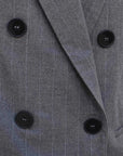 Zoom sur le double boutonnage du blazer femme chic gris à rayures fines, soulignant son élégance et sa sophistication.