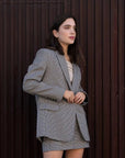 Femme portant un blazer pied-de-poule gris et blanc, blazer pied-de-poule femme