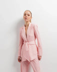 Portrait élégant d'une femme dans un Blazer Rose Femme Ceinturé, mettant en avant sa modernité et son confort.