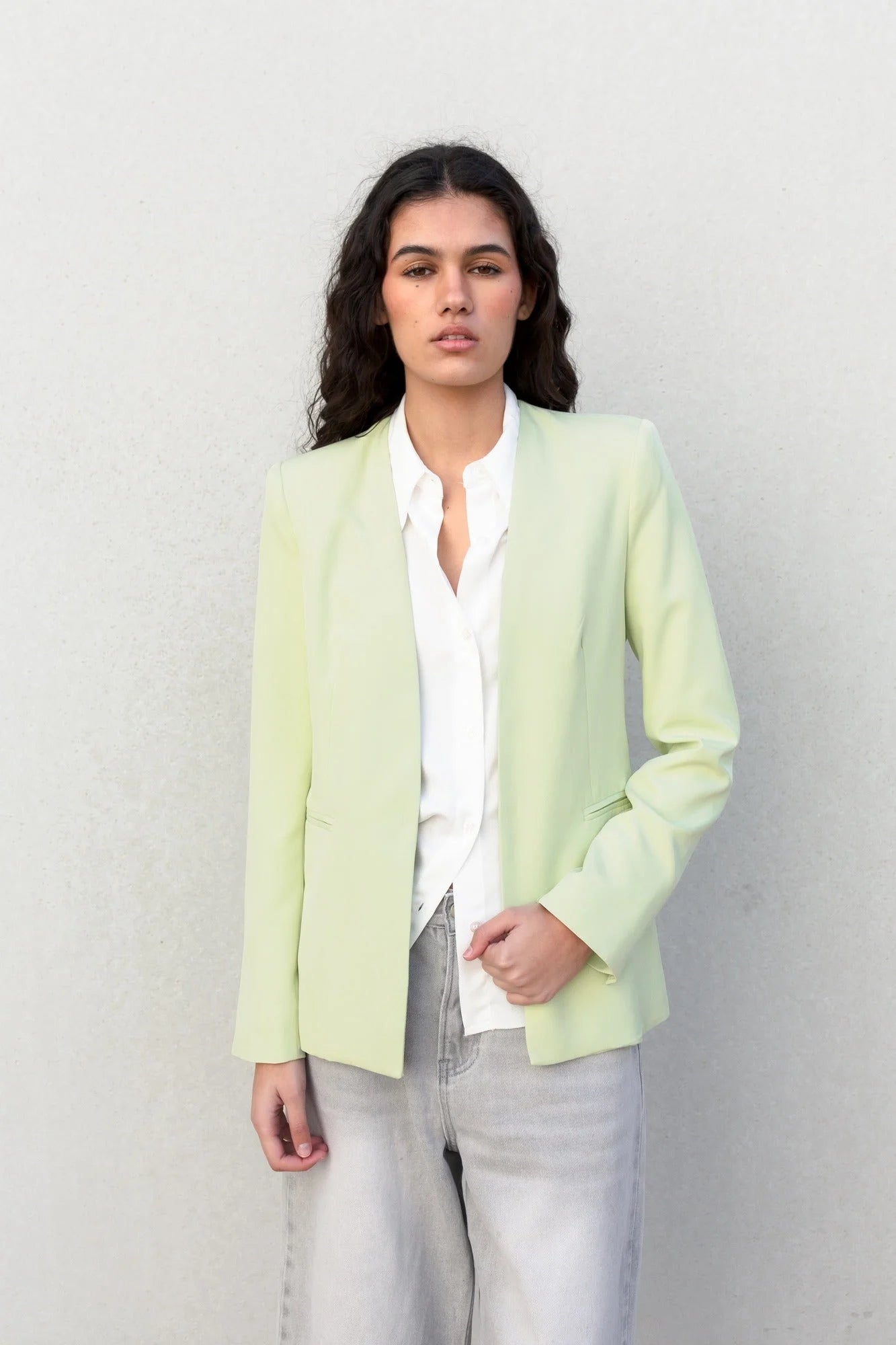 Blazer sans rabat vert clair pour femmes avec chemise blanche et jeans délavés pâles