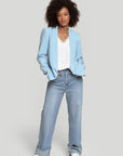 Profil d'un modèle portant un blazer femme chic bleu clair, accentuant la style contemporain.