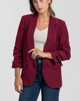 Femme affichant un blazer femme chic bordeaux, stylisé avec un débardeur crème, idéal pour les occasions habillées.