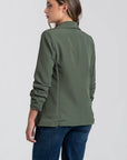 Profil arrière d'une femme dans un blazer femme chic vert, soulignant la qualité du tissu.