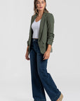 Modèle en blazer femme chic vert, complété par un pantalon large pour un style casual.
