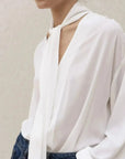 Blouse fluide élégante blanche à nouer avec manches longues et détail de cou