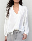 Femme portant une blouse fluide élégante blanche à nouer, livraison rapide