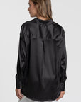 Vue arrière d'une blouse satinée femme élégante, en noir, mettant en avant le col chemise et la finition soignée.