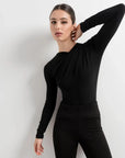Body Drapé Noir Style et Confort Réunis - Femme prenant une pose élégante, habillée d'un body manche longue femme, sur fond neutre, soulignant son chic intemporel.