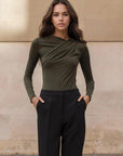 Body vert olive élégant avec drapé sur un modèle, combinaison parfaite avec un pantalon noir.