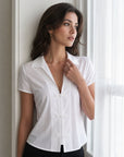 chemise blanche col V près de la fenêtre