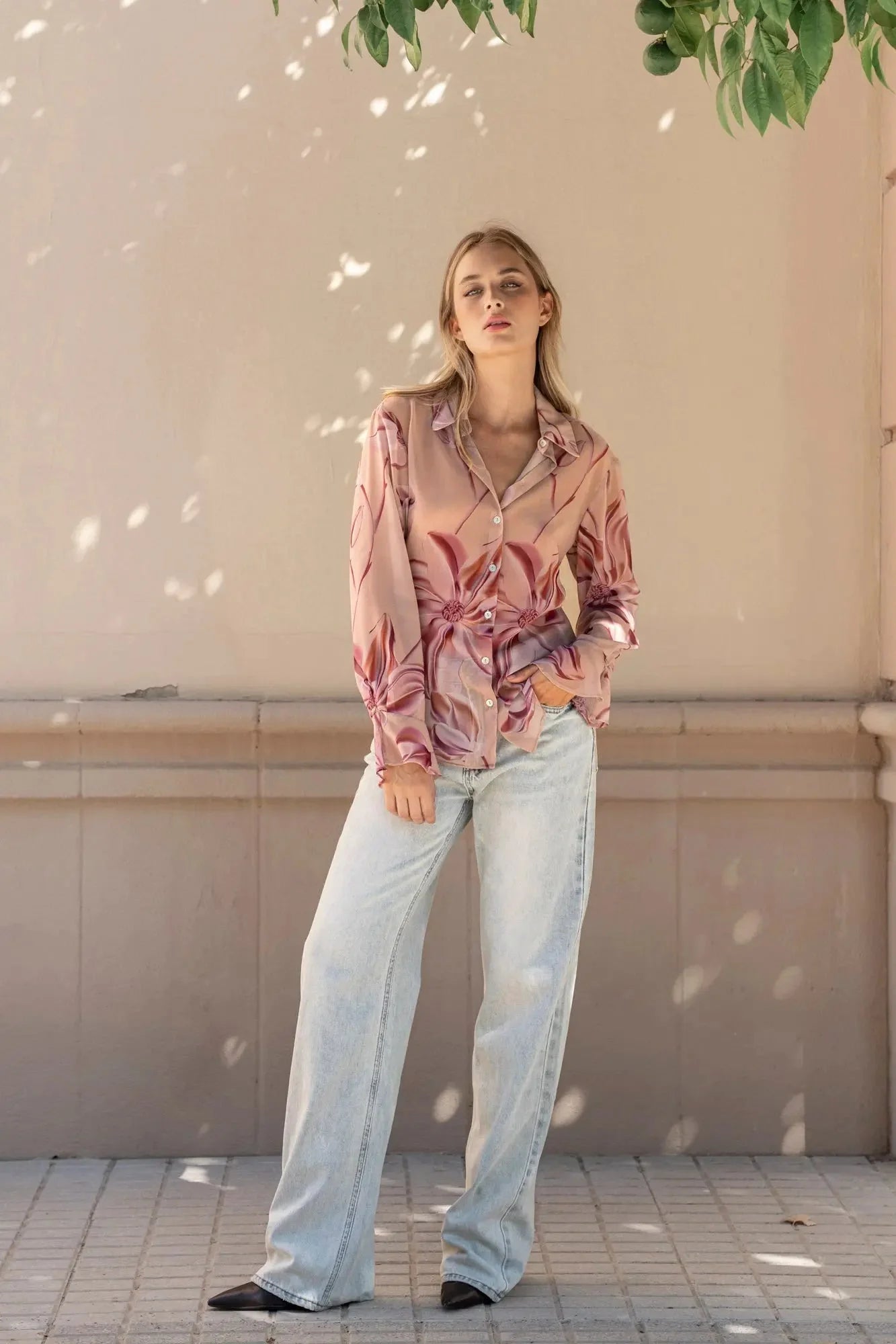 Femme portant une chemise imprimée semi-transparente à motifs floraux et jeans large