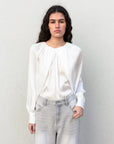 Femme portant une blouse satin élégante, chic et confortable, montrant le devant de la blouse satin avec un style moderne.