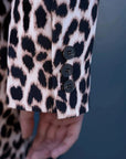 Détail des boutons sur la manche de la veste blazer leopard femme, style unique avec imprimé animal.