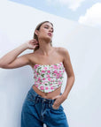 Modèle portant un Top Bustier Fleuri À Roses Inspiré Du Corset, affichant un style élégant avec des jeans décontractés, parfait pour toutes occasions.