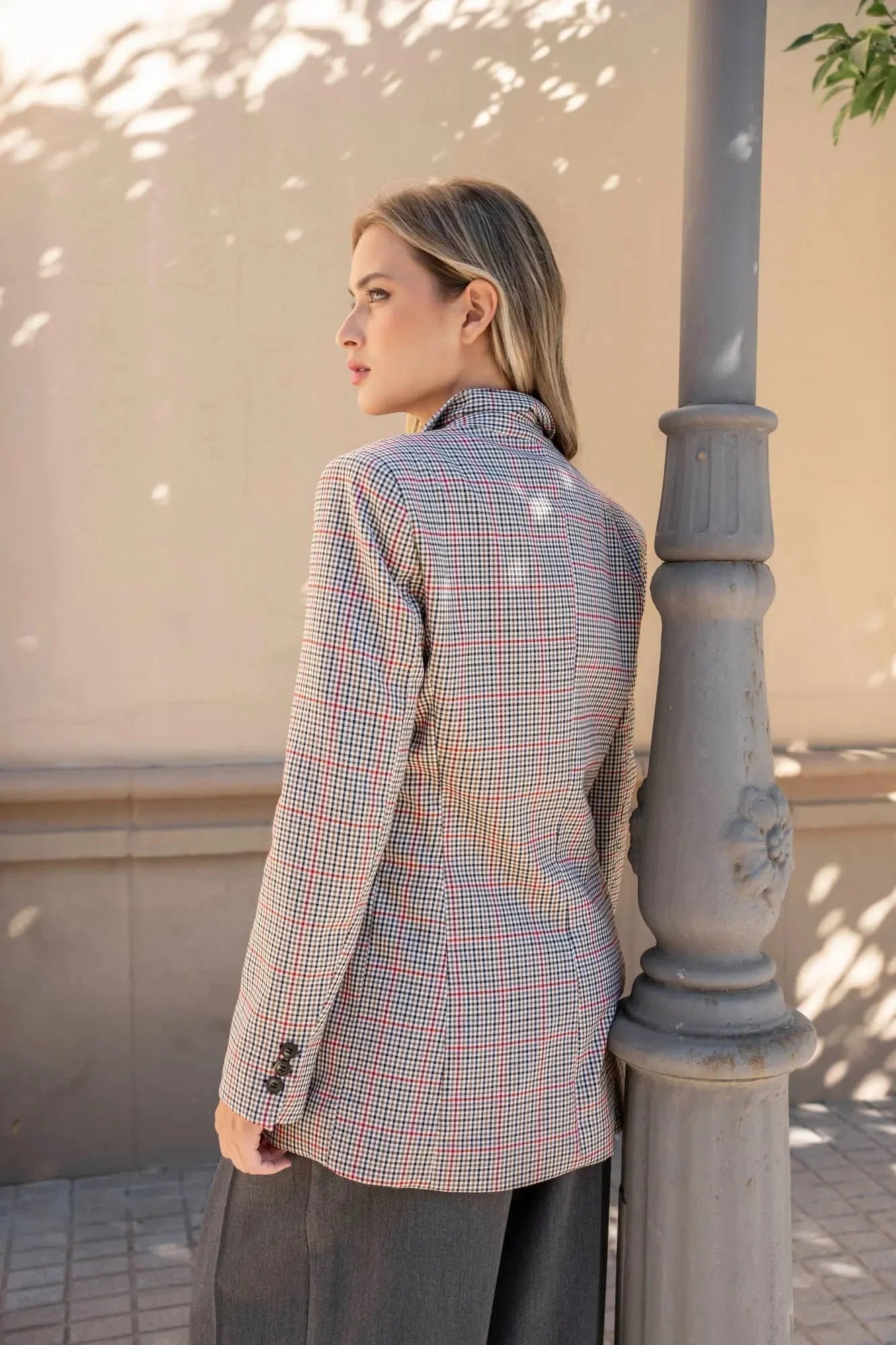Modèle avec le blazer femme double boutonnage, posant avec un look élégant, associé à un pantalon large.