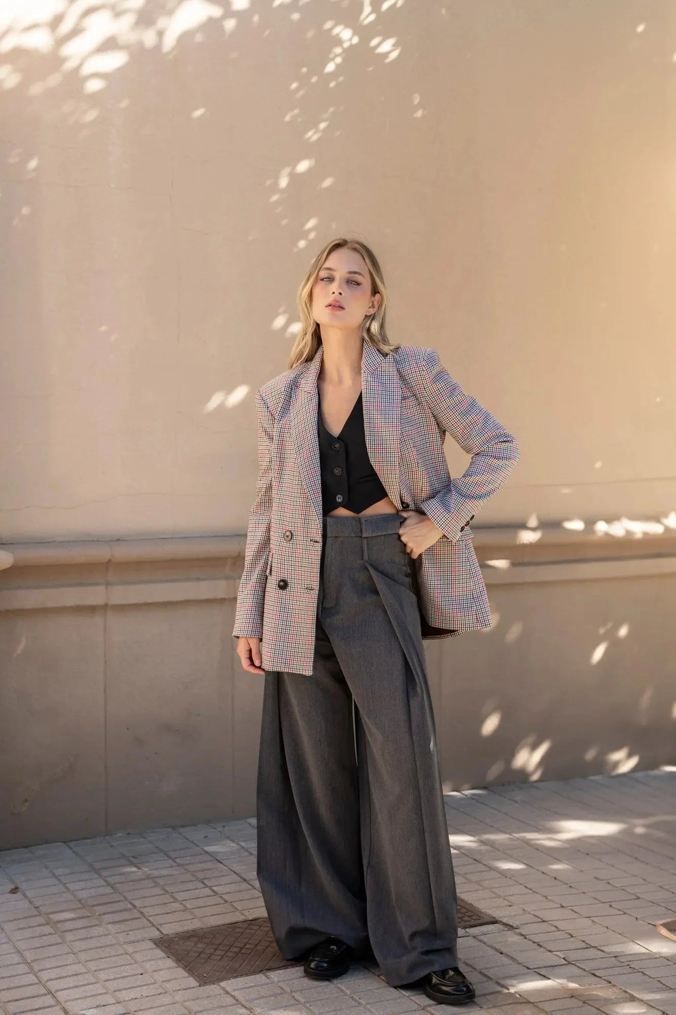 Vue de côté du modèle en blazer femme double boutonnage à carreaux de Sapiato, représentant un style tendance avec un pantalon chic.
