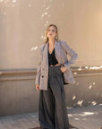 Vue de côté du modèle en blazer femme double boutonnage à carreaux de Sapiato, représentant un style tendance avec un pantalon chic.