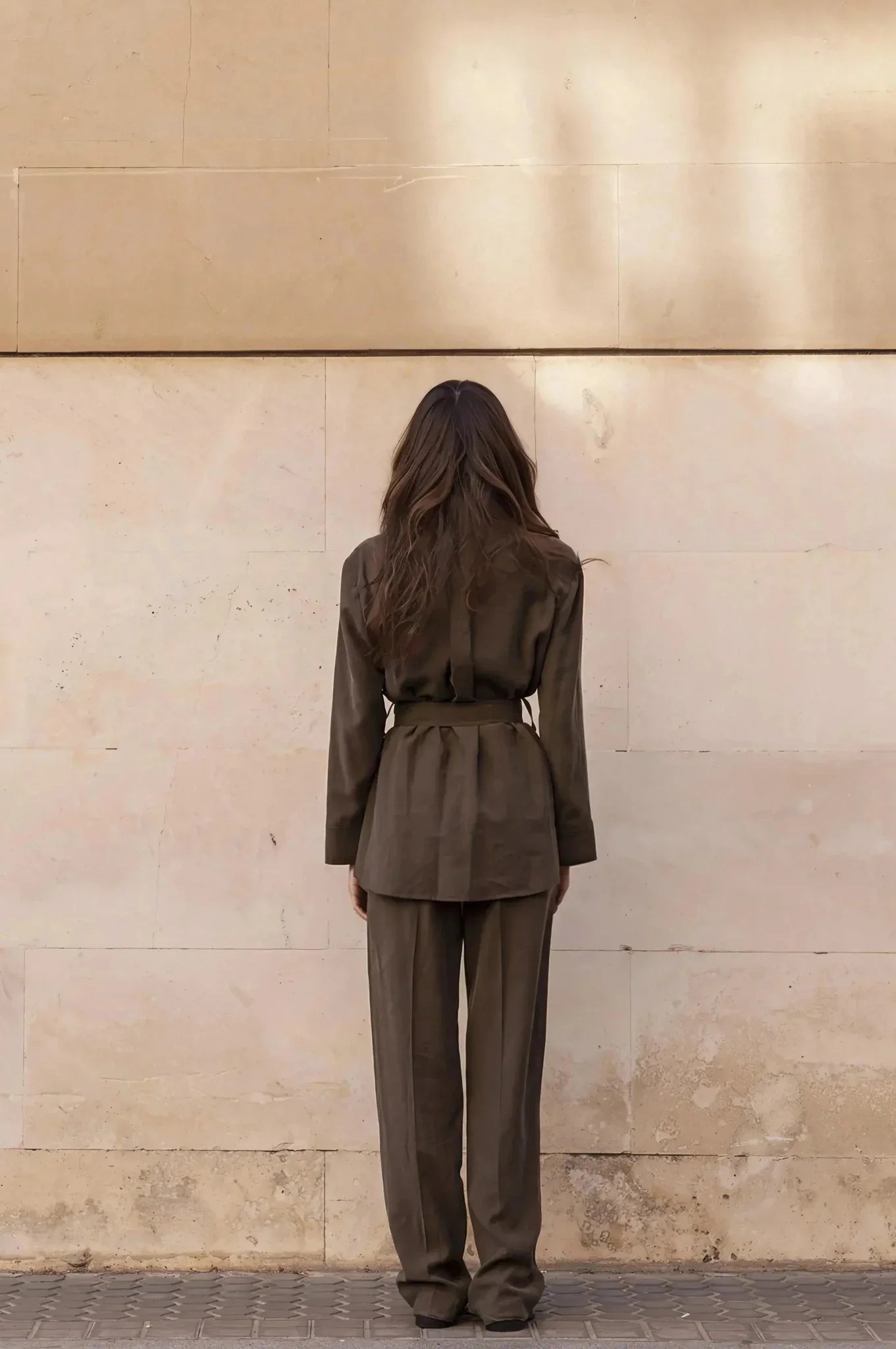 Femme vue de dos portant un ensemble coordonné chemise et pantalon marron