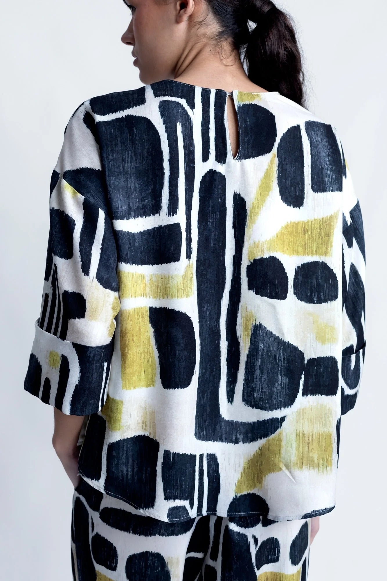 Top fluide imprimé abstrait noir et or avec dos clé et manches longues femme